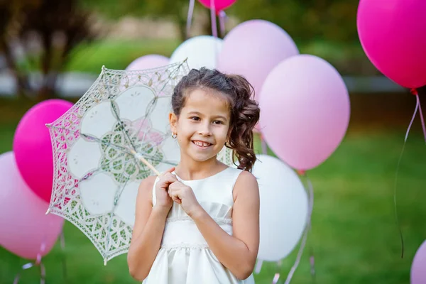 Retrato de encantadora menina em um vestido inteligente segurando um guarda-sol de renda branca — Fotografia de Stock