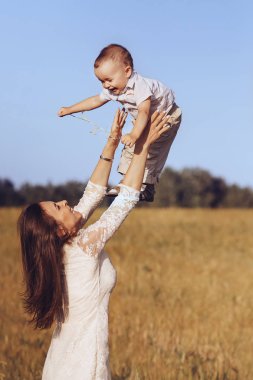 Güzel anne gülen oğlu havaya atar.