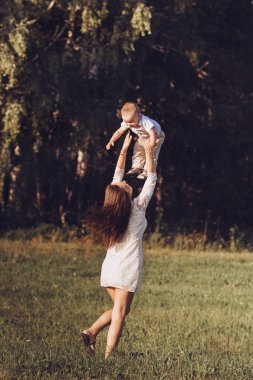 Güzel anne gülen oğlu havaya atar.
