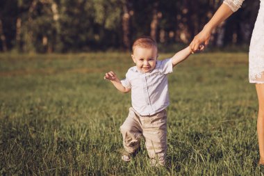 Küçük çocuğun annesinin elini tutarak alanı