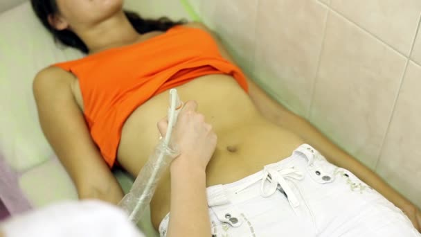 Un médico sostiene a una chica de ultrasonido abdominal — Vídeo de stock