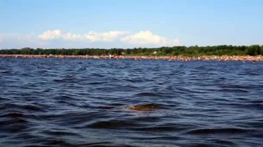 Suda uzun saçlı genç kadın ortaya çıkar ve dalga saç yapar