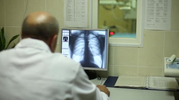 Orvos nézi egy X-ray képernyő — Stock videók