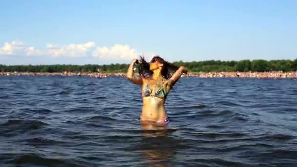 Жінка в сонцезахисних окулярах танцює у воді — стокове відео