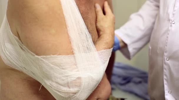 Läkare kopplingsförbehåll patienter armen med ett bandage — Stockvideo