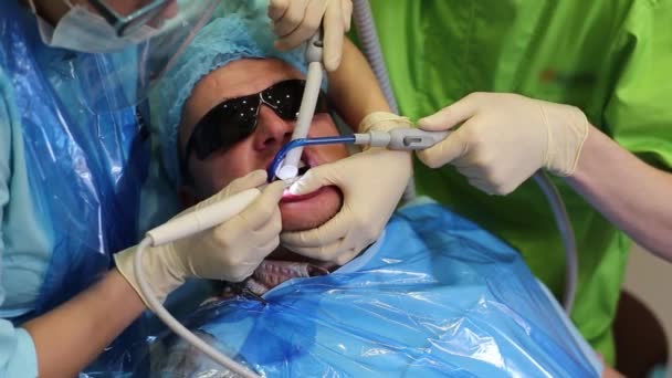 El hombre trata sus dientes en el dentista — Vídeo de stock