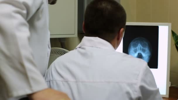 Dokter kijkt naar een röntgenfoto — Stockvideo
