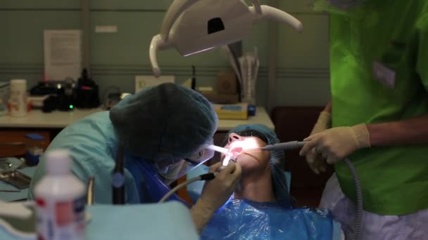 Doctor cleans teeth patient — Stock Video