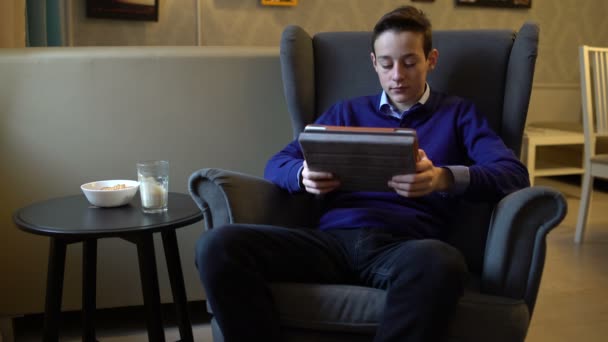 Young teenager playing game on tablet computer at home — Stock Video