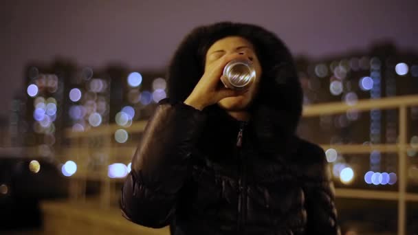 Женщина пьет пиво и ест чипсы на улице — стоковое видео