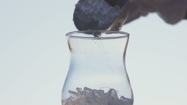 Бармен готує коктейль. Склянка, лід, апельсиновий сік і вода . — стокове відео