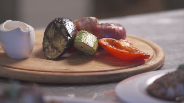 Roasted vegetables on the plate poured green sauce. — Stock Video