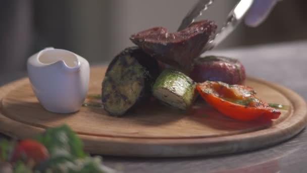 Кухар кладе смажене м'ясо, щоб прикрасити овочі. Частина 1 . — стокове відео