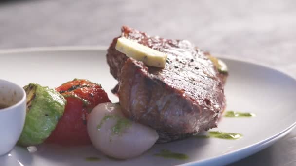 Šéfkuchař restaurace nalévá rozmarýn na steak se zeleninou. — Stock video