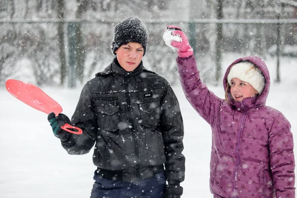 Tiener jongen en meisje spelen sneeuwballen — Stockfoto