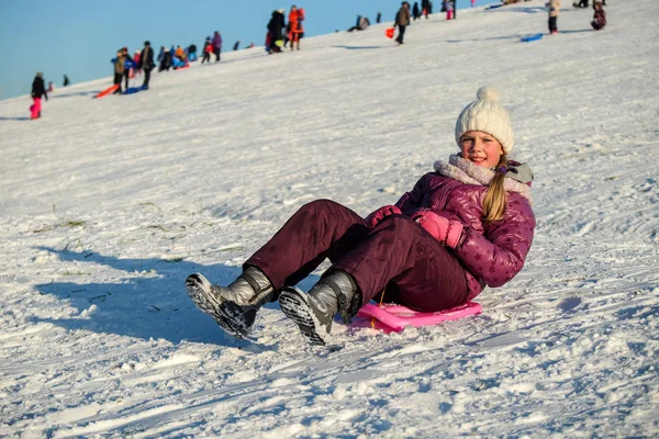 活跃的年轻可爱的女孩雪橇下山 — 图库照片