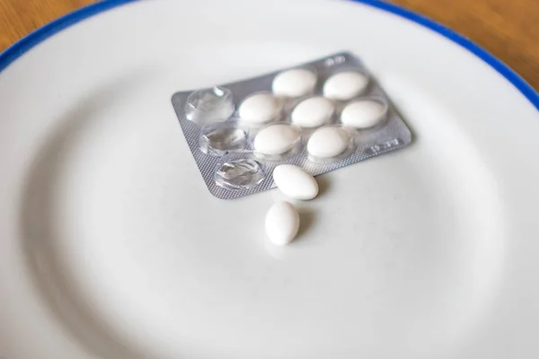 Set of pills in a plastic and foil package, on tray