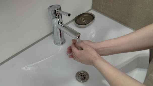 O femeie își spală mâinile cu săpun în baie — Videoclip de stoc