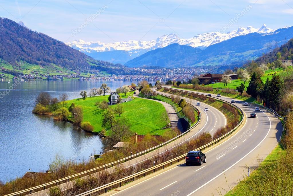 Swiss landscape with a highway, lake and mountains