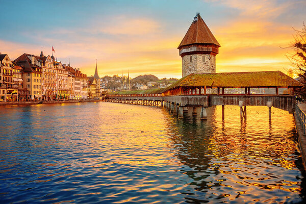 Lucerne historical Old town, Switzerland, view of wooden Chapel bridge and Water tower on dramatic sunrise