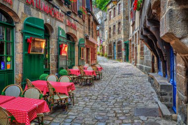 Dinan, Fransa - 10 Temmuz 2017: Tarihi Dinan kasabasında açık hava kafeleri olan tipik dar kaldırımlı cadde. Dinan, Fransa 'nın Brittany kentinde popüler bir turizm merkezidir..