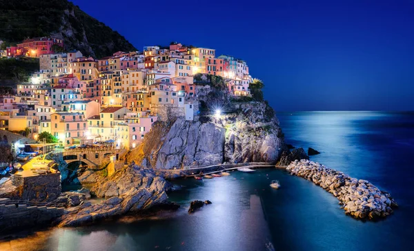 Night view of Manarola, Cinque Terre, a picturesque village on a rock cliff over Mediterranean sea in Liguria, Italy