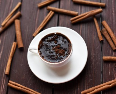 Bir koyu ahşap yüzeyde sıcak çikolata tarçın ile dekore edilmiştir.