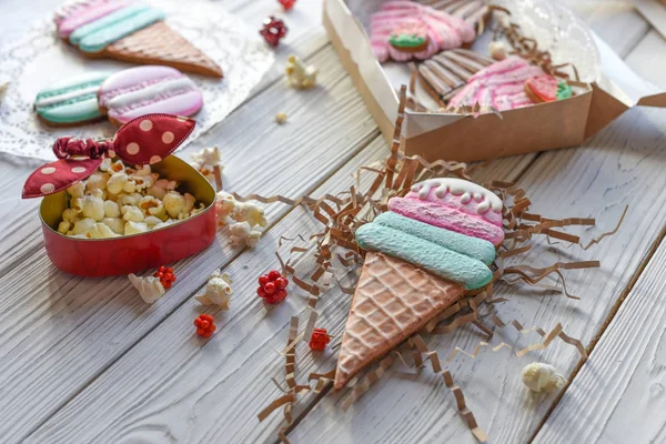 A bright pin up style photo with cookies in shape of ice-cream cones, macarons and cupcakes