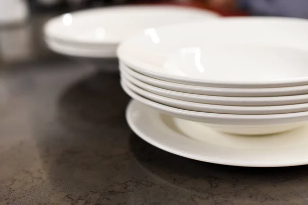 Фото со стопкой тарелок на кухонном столе — стоковое фото