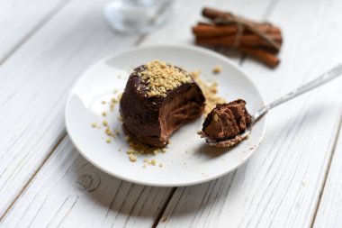 Beyaz bir tablo iştah açıcı bir çikolatalı cheesecake fındık ile dekore edilmiştir.  