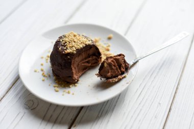 Beyaz bir tablo iştah açıcı bir çikolatalı cheesecake fındık ile dekore edilmiştir.  