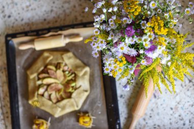 Açık bir elmalı turta ve bir buket parlak alan çiçek ile bir sıcak rahat fotoğraf