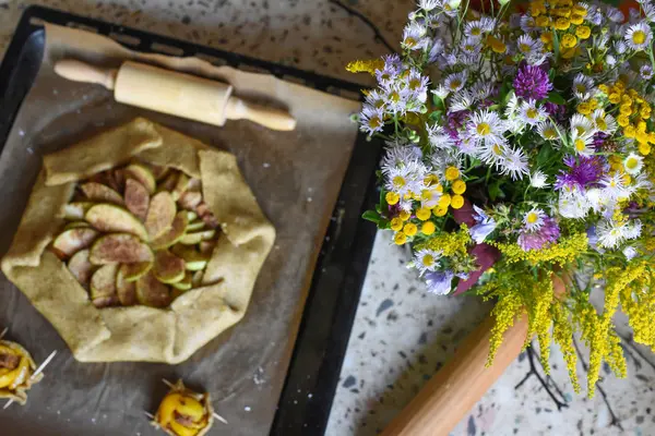 Açık bir elmalı turta ve bir buket parlak alan çiçek ile bir sıcak rahat fotoğraf