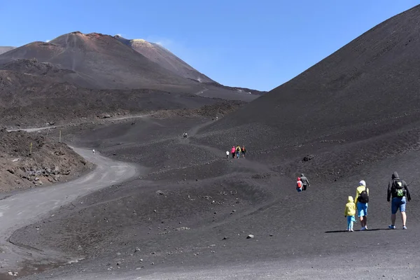 Silhouettes of people standing on a slope of Etna - the highest active volcano in Europe — Stock Photo, Image