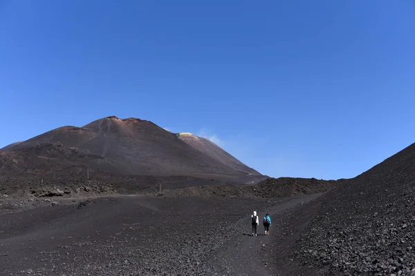 Silhouettes of people standing on a slope of Etna - the highest active volcano in Europe — Stock Photo, Image