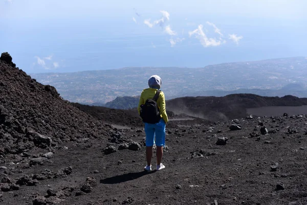 Uma jovem de pé em uma encosta de Etna - o vulcão ativo mais alto da Europa — Fotografia de Stock