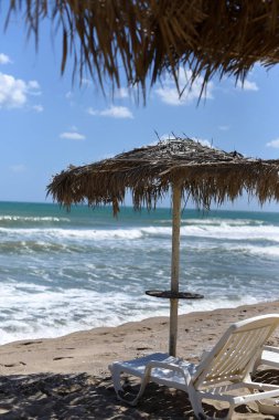 Bir şezlong ve şemsiye güzel bir ıssız plajda bir fotoğraf