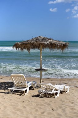 Şezlong ve bir şemsiye güzel bir ıssız plajda bir çift ile bir fotoğraf