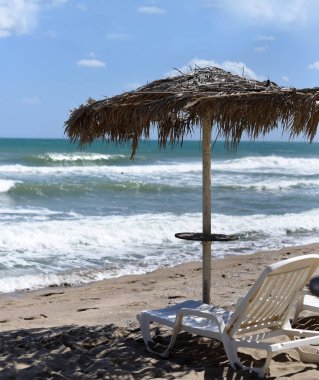 Bir şezlong ve şemsiye güzel bir ıssız plajda bir fotoğraf