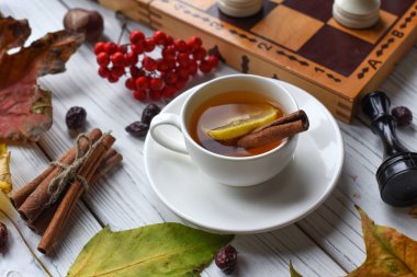 İki bardak çay, bitmemiş satranç oyunu, sonbahar yaprakları ve tarçın ile yönetim kurulu ile rahat bir fotoğraf