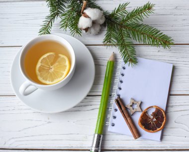 Festival kış kadar fotoğraf bir fincan çay, köknar dal, bir açılan not defteri, pencik ve decation öğeleri ile alay etmek