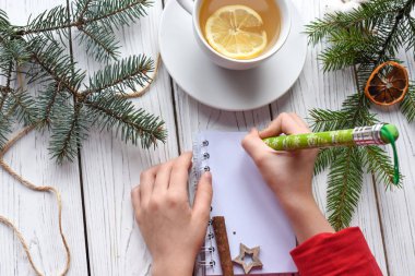 Bir not, bir cuo çay yazarak çocuk elleri şenlikli bir fotoğrafını anf Noel dekorasyon