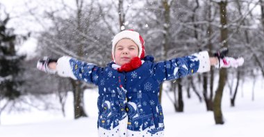 Gülümseyen bir küçük kız kış ve kar keyfi