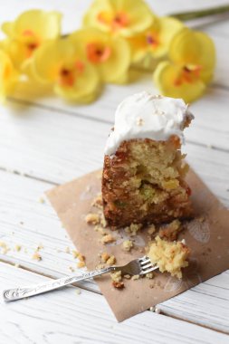 Bir fotoğraf geleneksel Paskalya kek ve bir beyaz tahta yüzeyi şenlikli dekorasyon bir dilim ile 