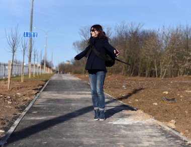 Bir şehir sokakta ince çekici genç bir kadının bir dymanic erken bahar portresi