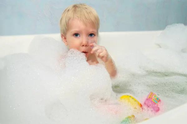 Un enfant se baigne dans une baignoire . Images De Stock Libres De Droits