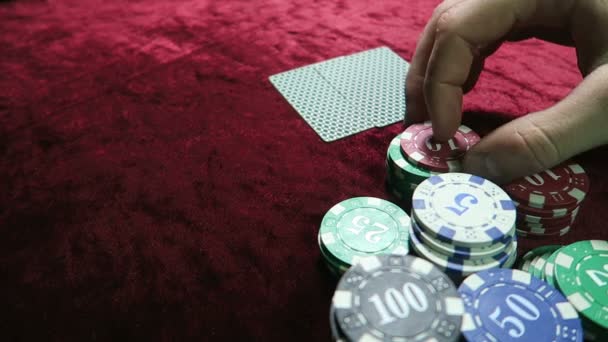 Gioco del poker. Quell'uomo fa una scommessa. Stenditi intorno alle patatine. il gioco è su un tavolo di velluto di stoffa rossa . — Video Stock