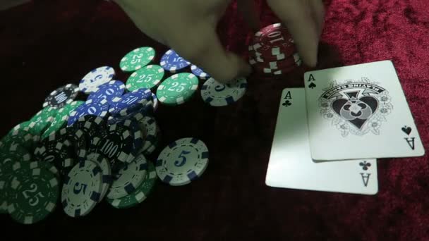 Juego de poker. la combinación de un par de ases. una oportunidad de ganar. El hombre hace una apuesta. tumbarse alrededor de las fichas. el juego está en una mesa de terciopelo de tela roja . — Vídeos de Stock