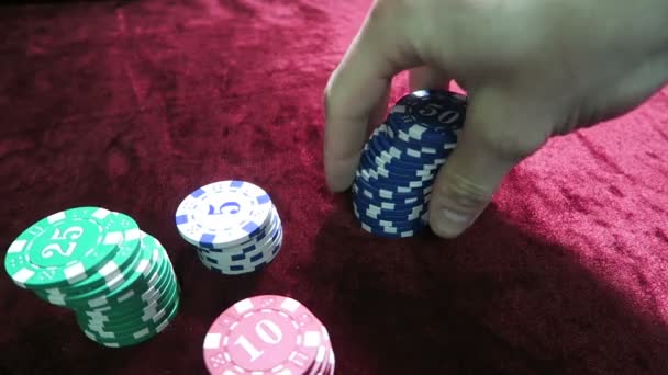 Hra pokeru. vyprávění čipy v ruce. leží kolem čipy. hra je na stole velur červený šat. — Stock video