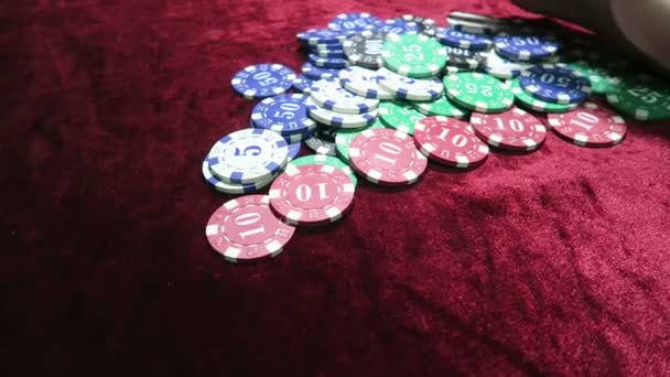 Juego de poker. pila de fichas de diferentes denominaciones. persona gana y se lleva todas las fichas usted mismo. el juego está en una mesa de terciopelo de tela roja . — Vídeos de Stock